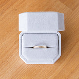 14k yellow gold thin zion flat vertical hammered wedding band in a ring box