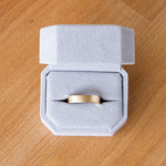 14k yellow gold Zion flat wide vertical hammered wedding band in a ring box
