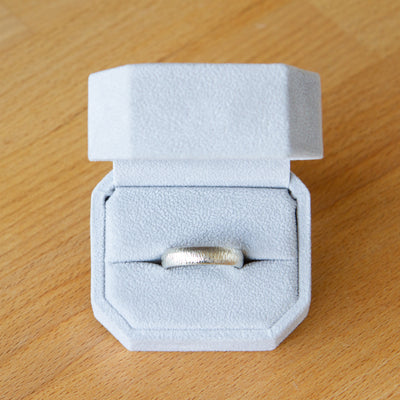 14k white gold half round Zion band in a ring box by Corey Egan