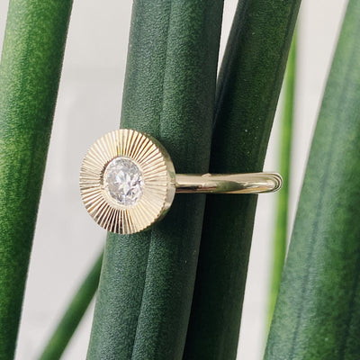 Round antique old European diamond in a 14k yellow gold Aurora ring with an engraved halo border side view