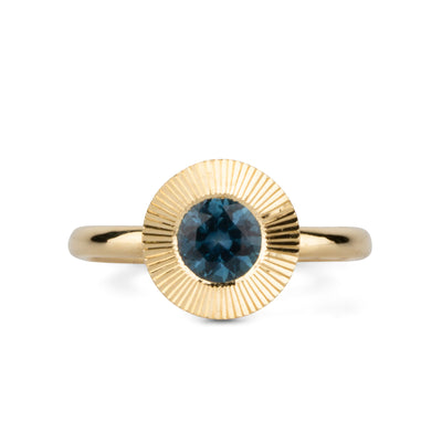 Round Teal Montana sapphire in a 14k yellow gold Aurora ring with an engraved halo border. 