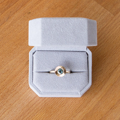 Round mint green Montana sapphire in a 14k yellow gold Aurora ring with an engraved halo border in a gift box