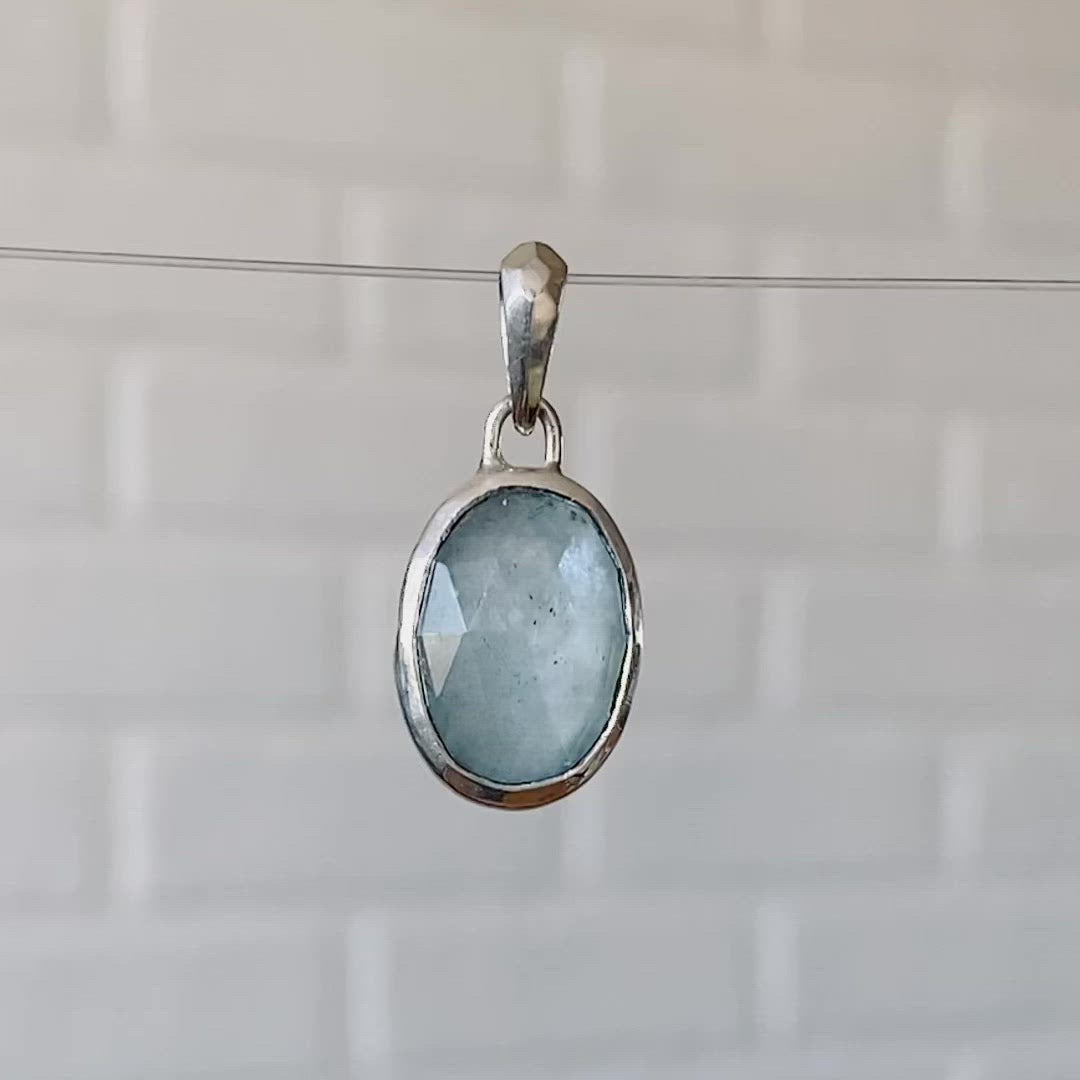 Oval Rose cut cloudy aquamarine in a sterling silver bezel pendant with a faceted silver bail.