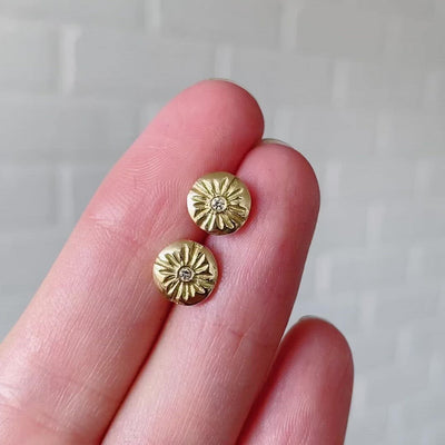 Small round carved sunburst stud earrings with diamond centers in gold