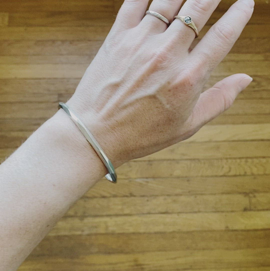 Thin Denali Faceted Bangle on a wrist by Corey Egan