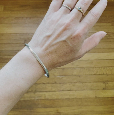 Thin Denali Faceted Bangle on a wrist by Corey Egan