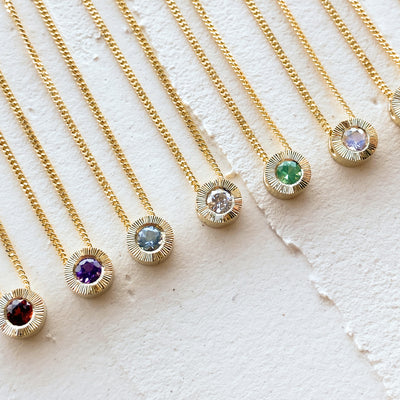 birthstone Aurora pendants in 14k yellow gold in all birthstones with an engraved halo border