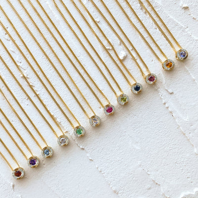 Birthstone Aurora necklaces in 14k yellow gold in each birthstone: garnet for January, amethyst for February, aquamarine for March, diamond for April, emerald for May, moonstone for June, ruby for July, peridot for August, blue sapphire for September, pink tourmaline for October, citrine for November, and tanzanite for December